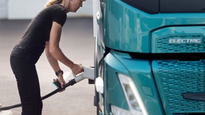 Kvinna som laddar en eldriven lastbil från Volvo