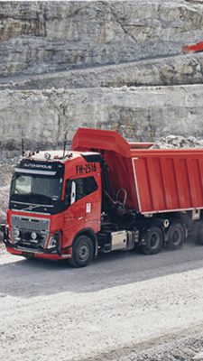 Orange autonomous truck driving in a quarry