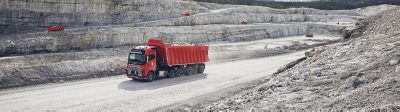 Orange autonomous truck driving in a quarry