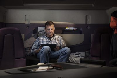 A man reclines as he looks at an iPad