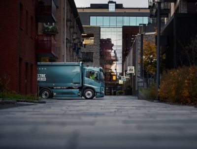 An FM Electric driving in an urban environment, surrounded by apartments