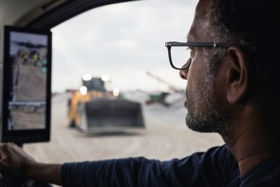 A man inside a truck with hands on the steering wheel