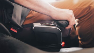 En sjåfør bruker en setemontert I-Shift-knapp for å skifte gir