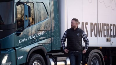 En mann står foran en LNG-drevet Volvo-lastebil