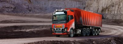 Self-driving truck loaded with crushed stones running down a road in a quarry