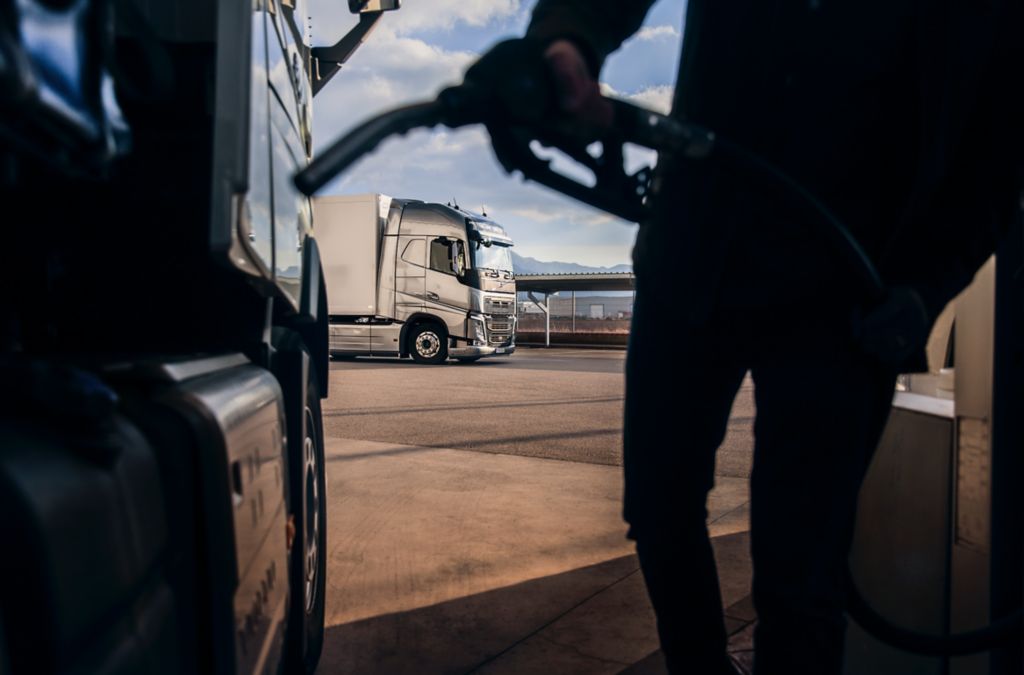 Volmax tips og trix. Mann fyller diesel på lastebil, foran en annen Volvo lastebil.
