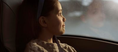 Little girl looking out of bus window