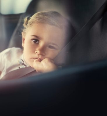 Girl with safety belt in bus window