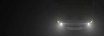 An image showing the darkened front of the GML Eco Range City bus with the headlights fully lit.