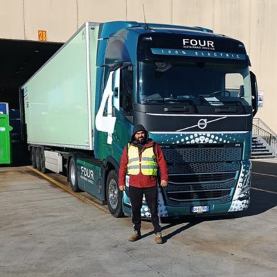 Férfi áll egy kék Volvo teherautó előtt