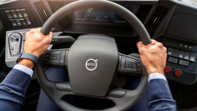 A bus driver’s hand with a firm grip of the steering wheel of a Volvo electric bus