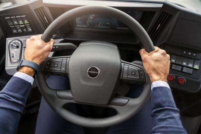 A bus driver’s hand with a firm grip of the steering wheel of a Volvo electric bus