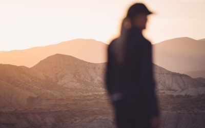 Image in profile of person standing in mountain landscape 