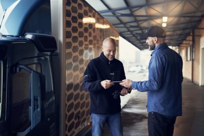 Driver and customers' customer in front of truck (FM).