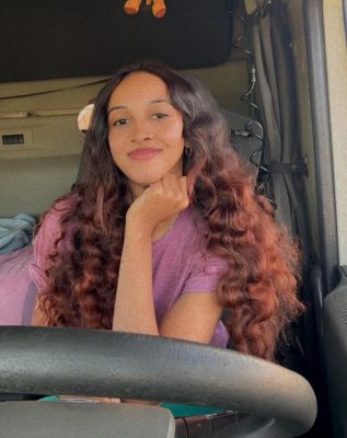 Zureena Samuels at the drivers seat of the truck posing for a photograph