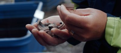 a volvo employee inspecting some recyclable material