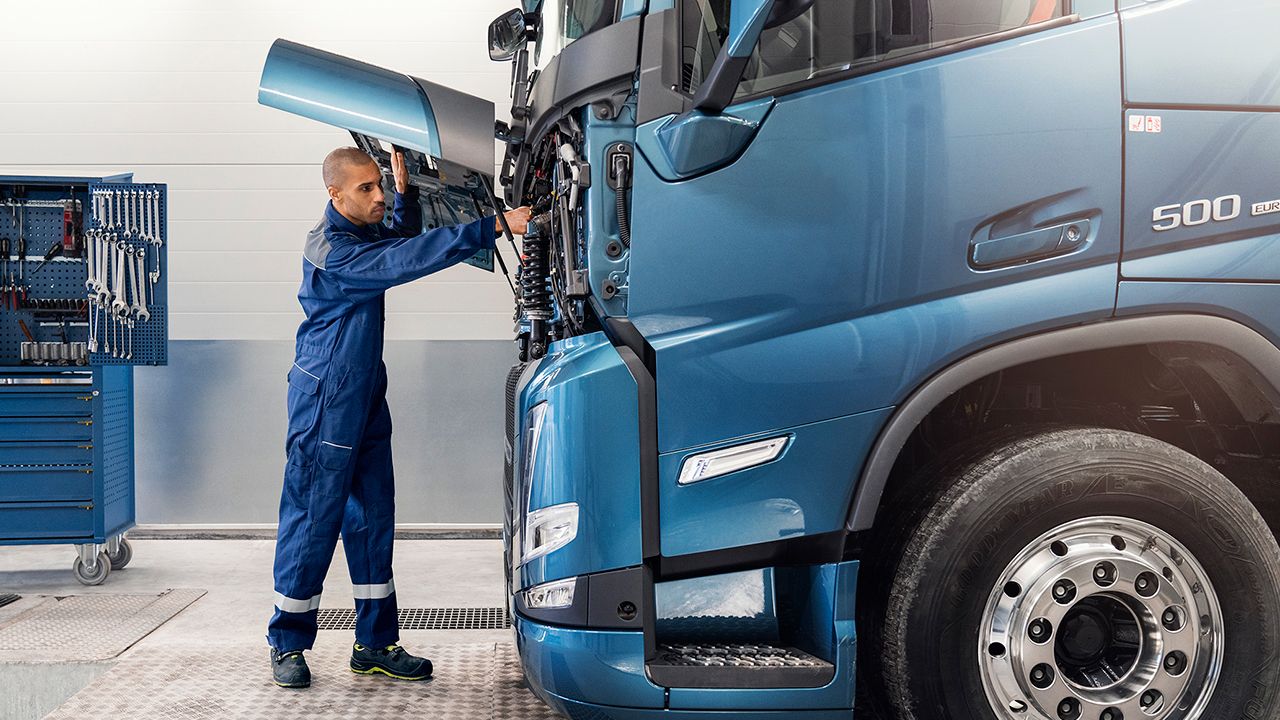 Man standing in front of truck with the hood open