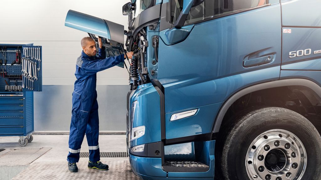 Man standing in front of truck with the hood open