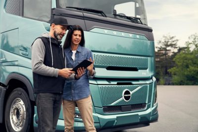 Vyras ir moteris žiūri į planšetinį kompiuterį priešais „Volvo FH Aero Electric“
