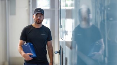 A Volvo employee delivering a spare part in a service workshop. 