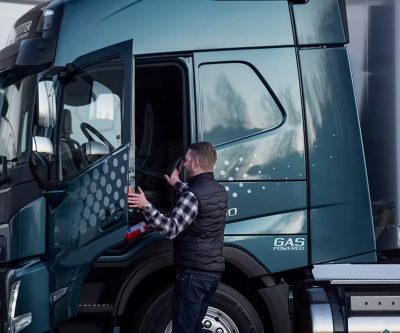 Čovjek otvara vrata i ulazi u kabinu Volvo kamiona, gledano sa strane u vanjskom okruženju.