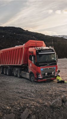 Man sitting on the ground in front of a truck