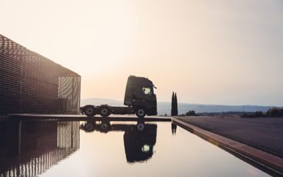 O Volvo FH16 Aero refletido na água, visto de lado