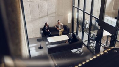 Two women and a man sitting in a lounge area discussing.