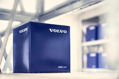 O cutie albastră cu piese originale Volvo pe un raft