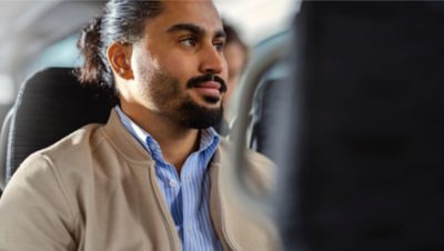 A  man riding in an electric bus