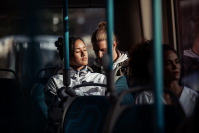 Två passagerare som njuter av en behaglig åktur i en elbuss