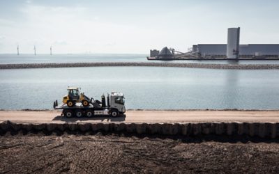 Volvo FMX with construction equipment on flatbed