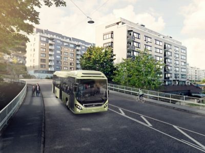 A full hybird bus on the street in an urban area