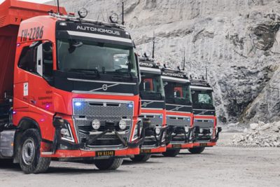 A line of red Volvo autonomous FH16s bearing the name FH2286