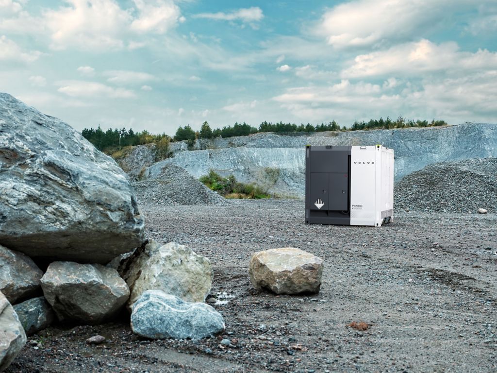 The image shows a PU500 in a quarry with a few boulders in the foreground