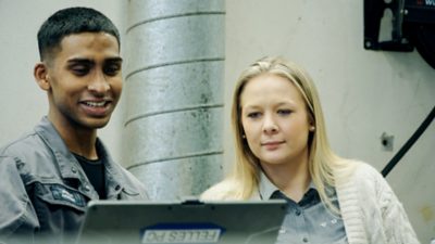 To unge mennesker som jobber på et Volvo-verksted
