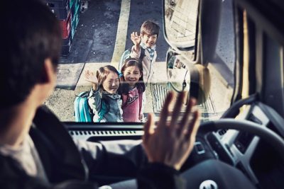 Children waving at truck driver