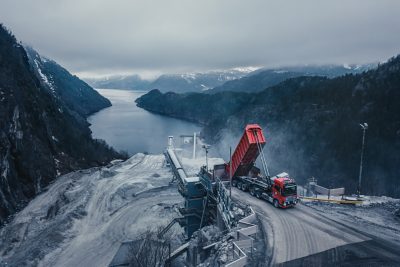 Orange autonomous truck driving in a quarry