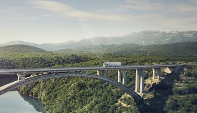 Volvo Trucks FH driving on a bridge, visualizing conneciting to services in the cloud.