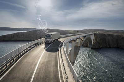 Prijungtas „Volvo“ sunkvežimis važiuoja per tiltą atokioje vietovėje