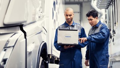 Two service technician standing in a workshop looking at a computer