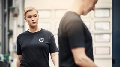 Two Volvo Buses technicians meet in a Volvo workshop.