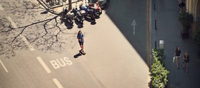 patinador junto a un carril de autobús en la ciudad