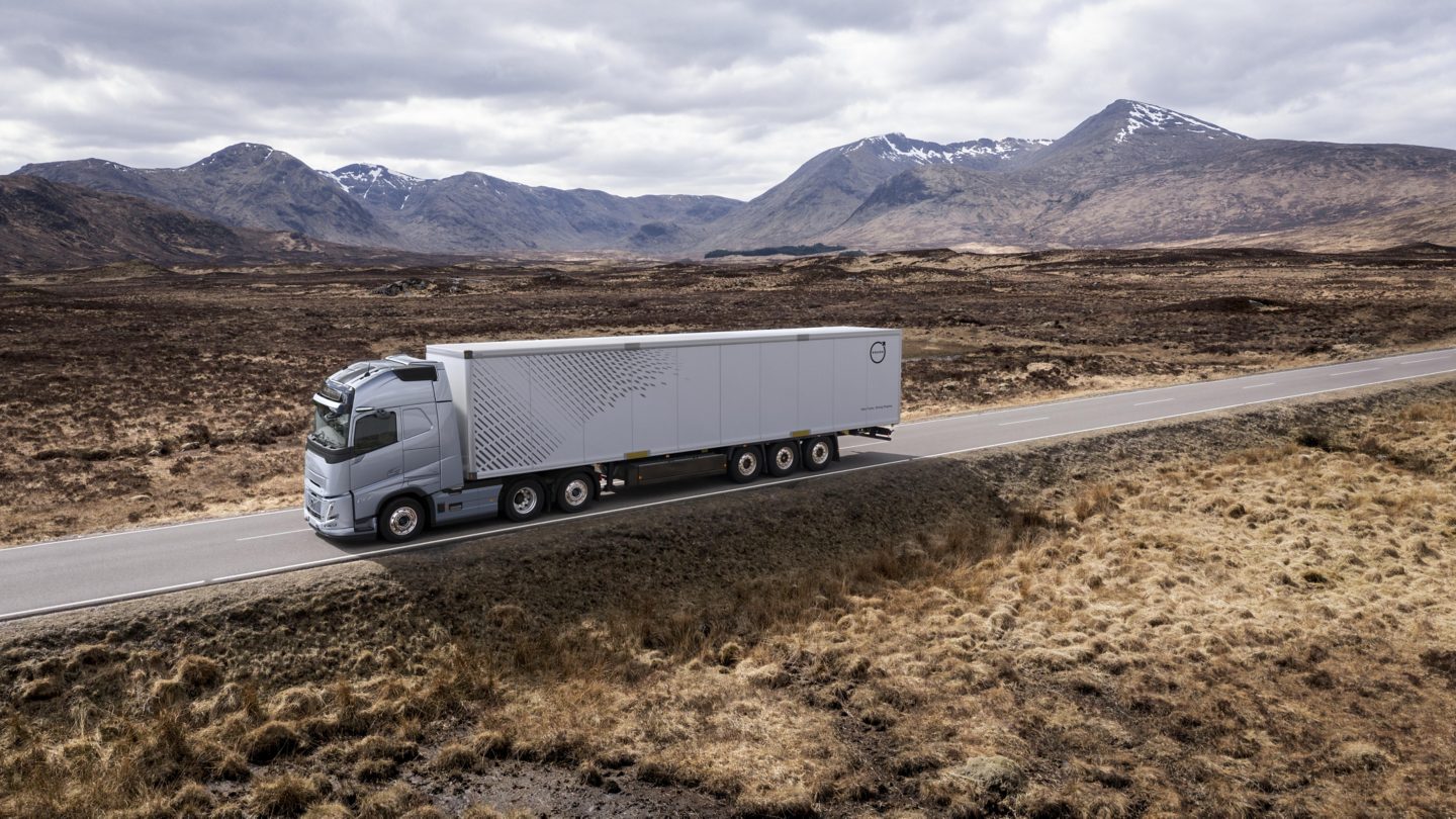 A truck drives through a mountainous desert landscape