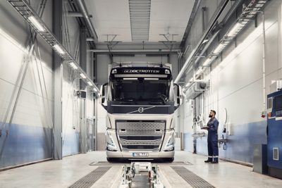 Técnico de assistência Volvo, segurando um computador, olha para um camião