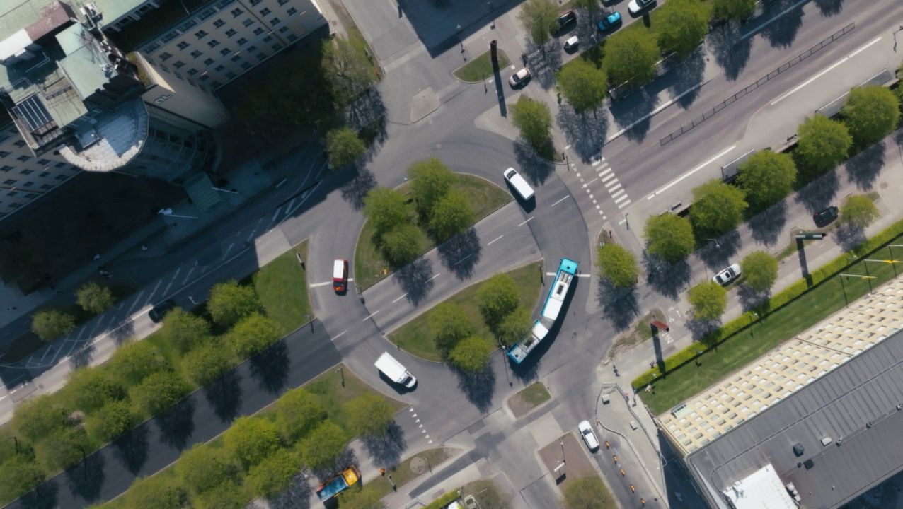 Aerial shot of a bus going around a roundabout with trees