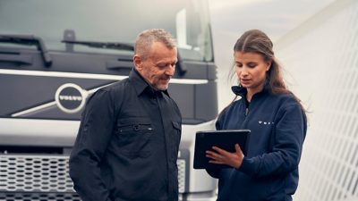 Fahrer mit Klemmbrett neben Lkw