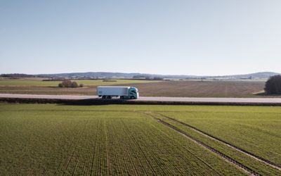 Osoba jdoucí před vozidlem Volvo FM Electric