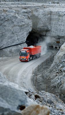 Orange autonomous truck driving in a quarry