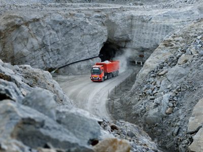 Orange autonomous truck driving in a quarry